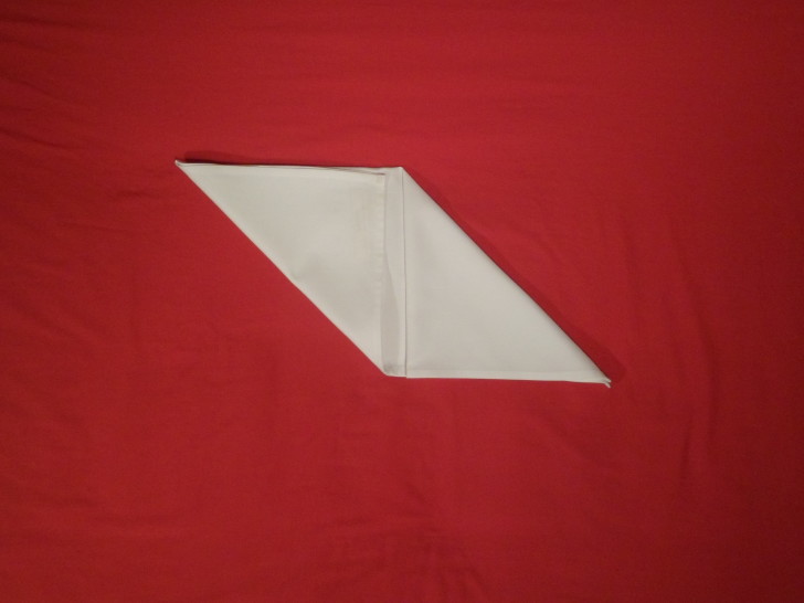 Napkin Folding Bishops Hat Step Four fold the bottom left corner up to the top centre creating a rhombus like shape
