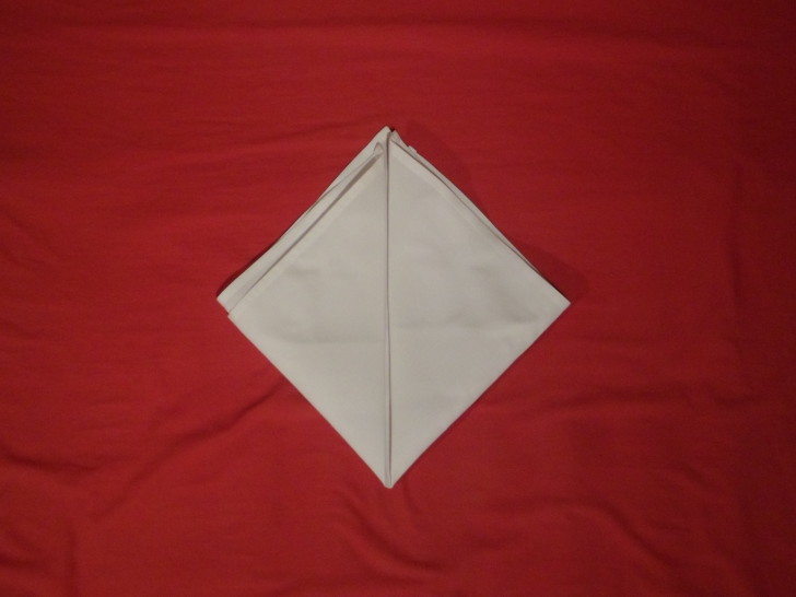 How To Fold Napkins The Crown Fold Step Four Copy the same fold as the previous step this time with the left corner. 