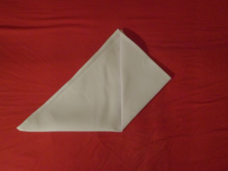 Folded Napkin Pyramid Fold Step  Four Fold the bottom right corner of the triangle up to the top centre. 