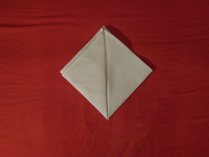 Folded Napkin Pyramid Fold Step Five Repeat the same action as the previous but with the bottom left corner creating a diamond.